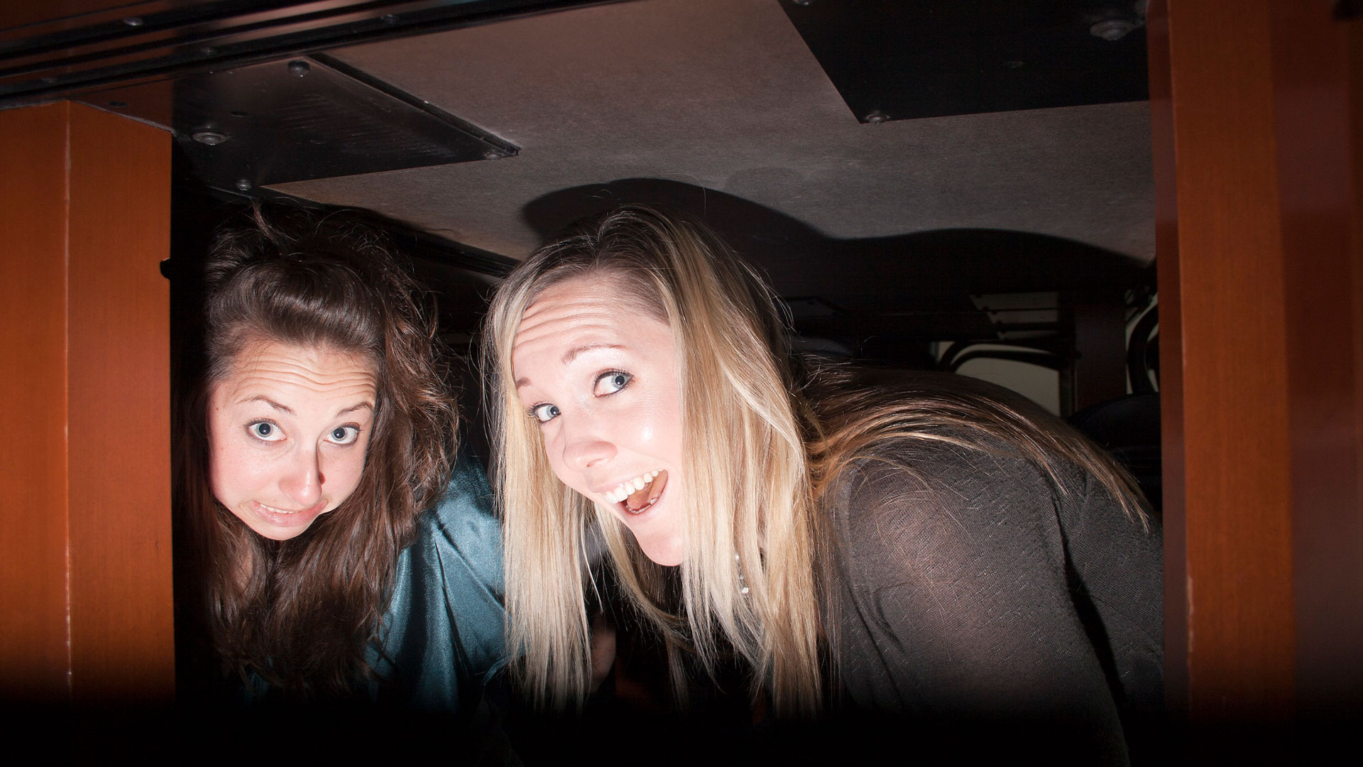 Two people taking shelter under a desk during the Great Shakeout drill
