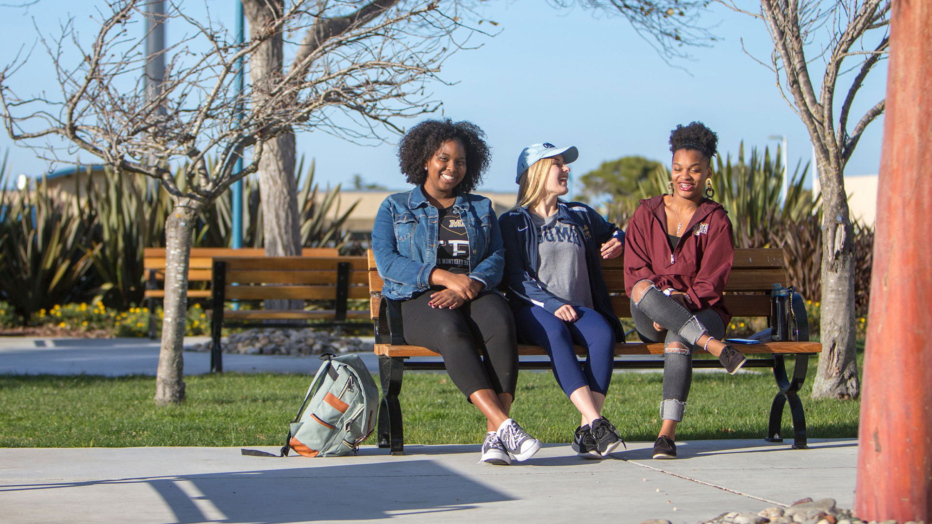 Photo: Students sitting on a bench on campus