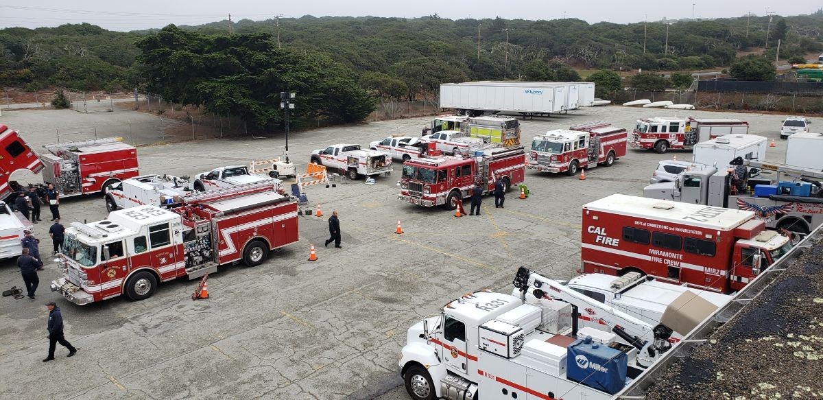 Firefighting and ground support vehicles in a motor pool at a CSUMB parking lot.