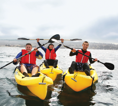 Three students kayaking in the ocean