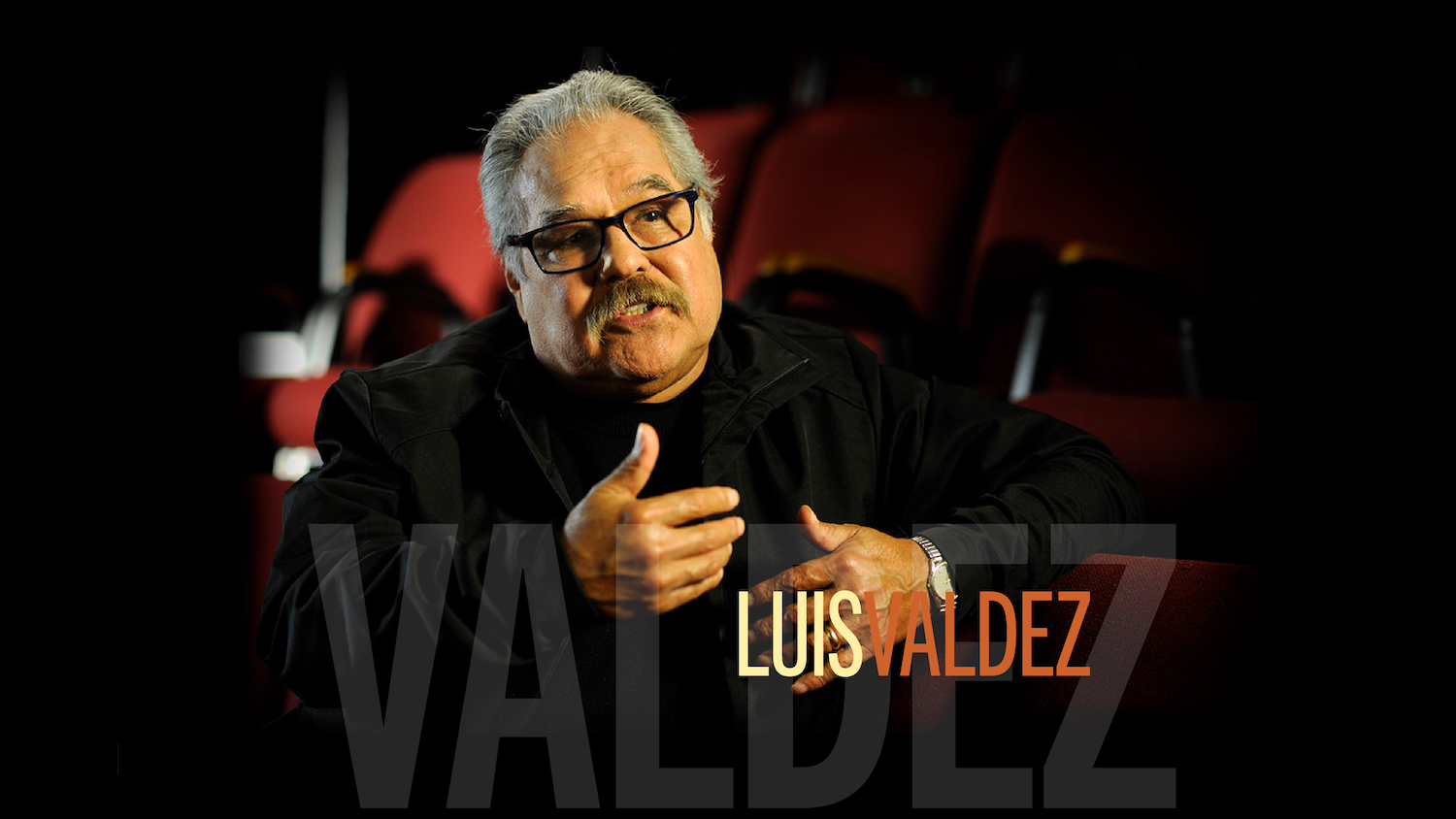 Luis Valdez photo of him speaking and gesturing with hands