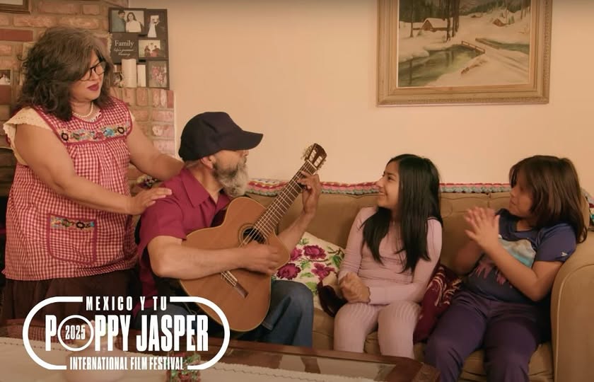 2 children sitting on couch, man plays guitar, woman observes