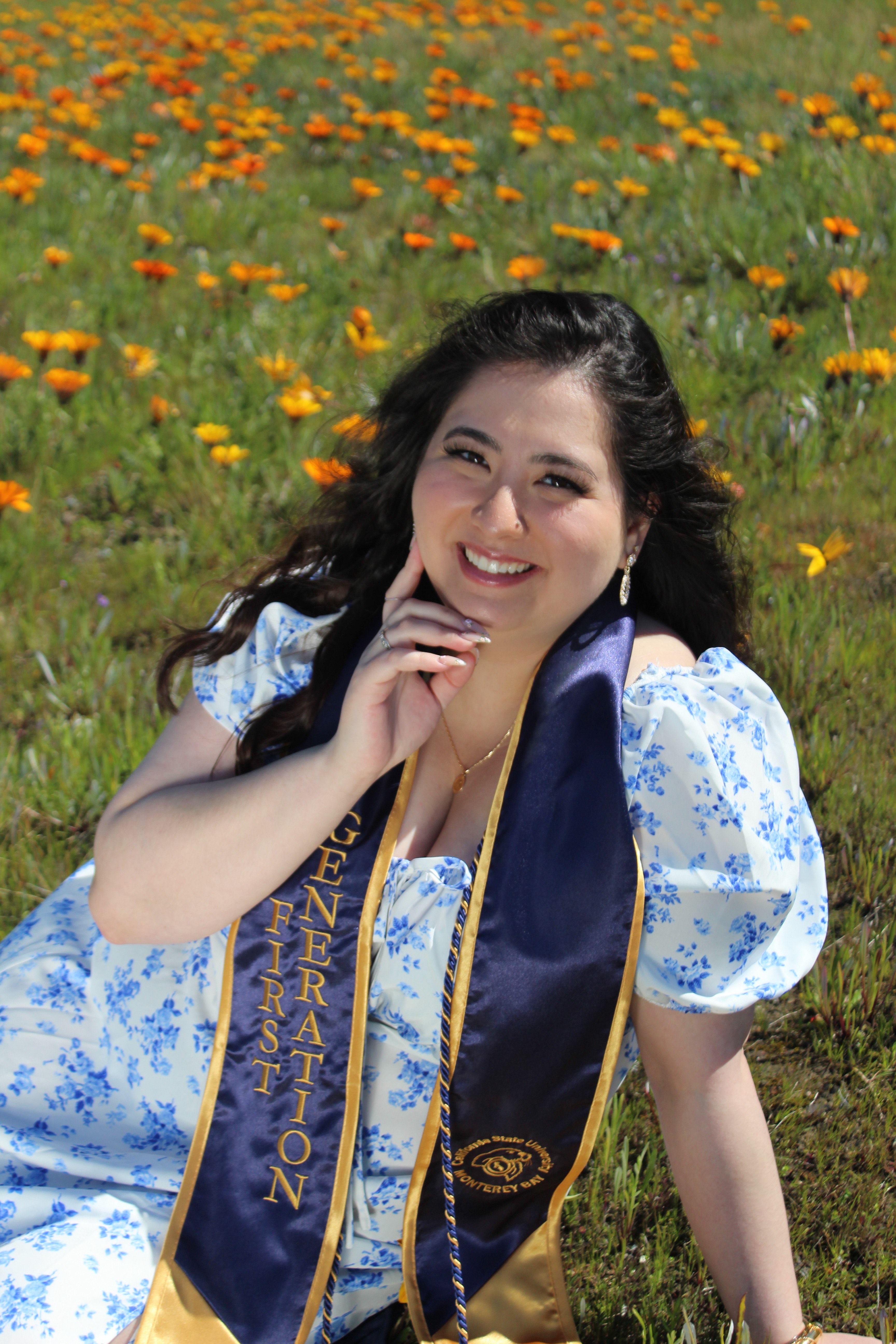 Natalie Carbonel smiles at camera wearing commencement stole