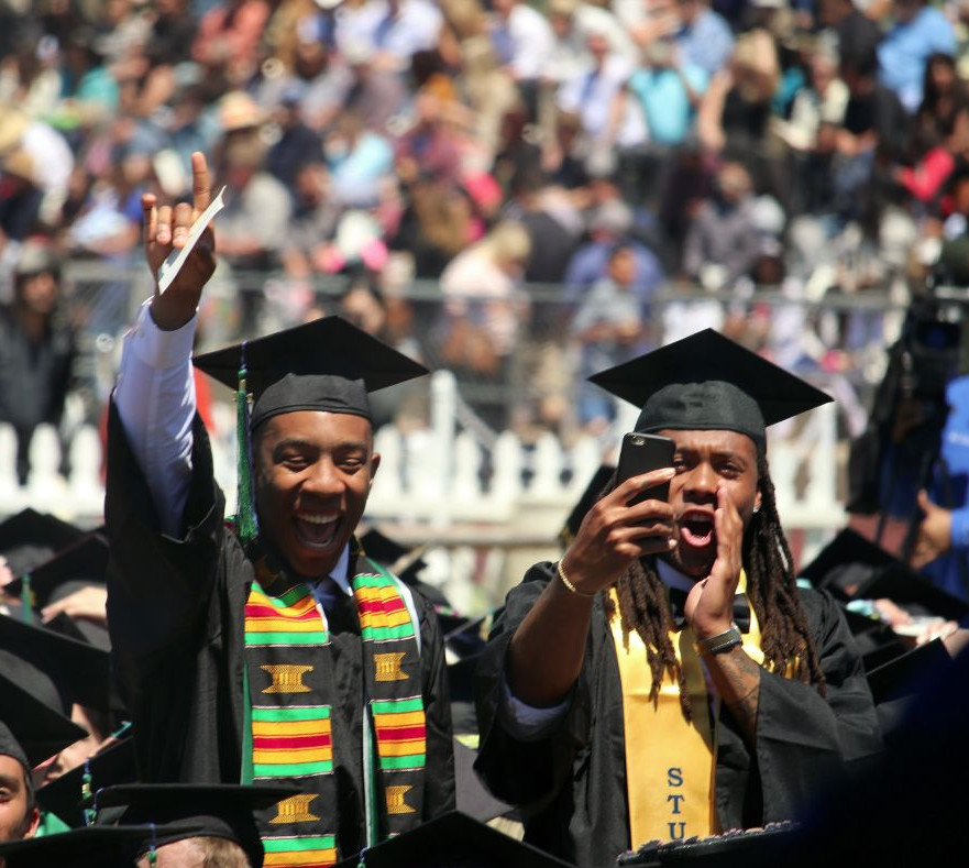 Two students cheering during 2017 commencement ceremony.