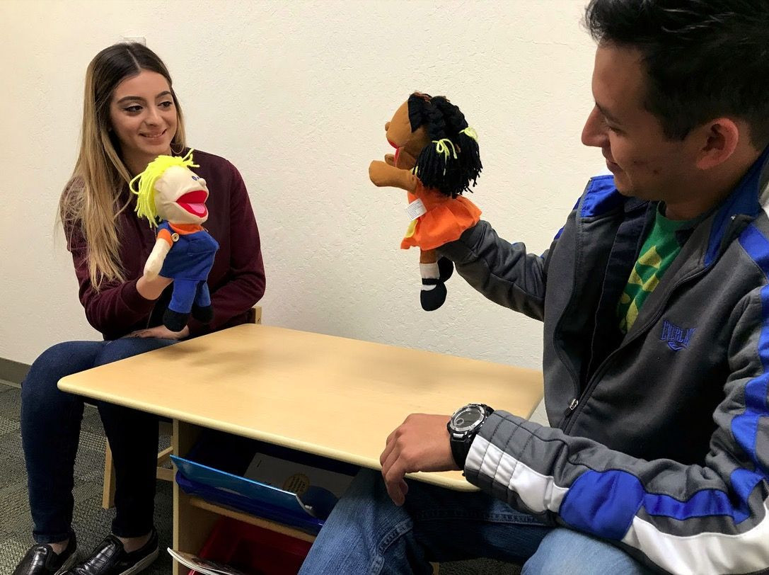 two students roleplaying with puppets in the DS2 lab