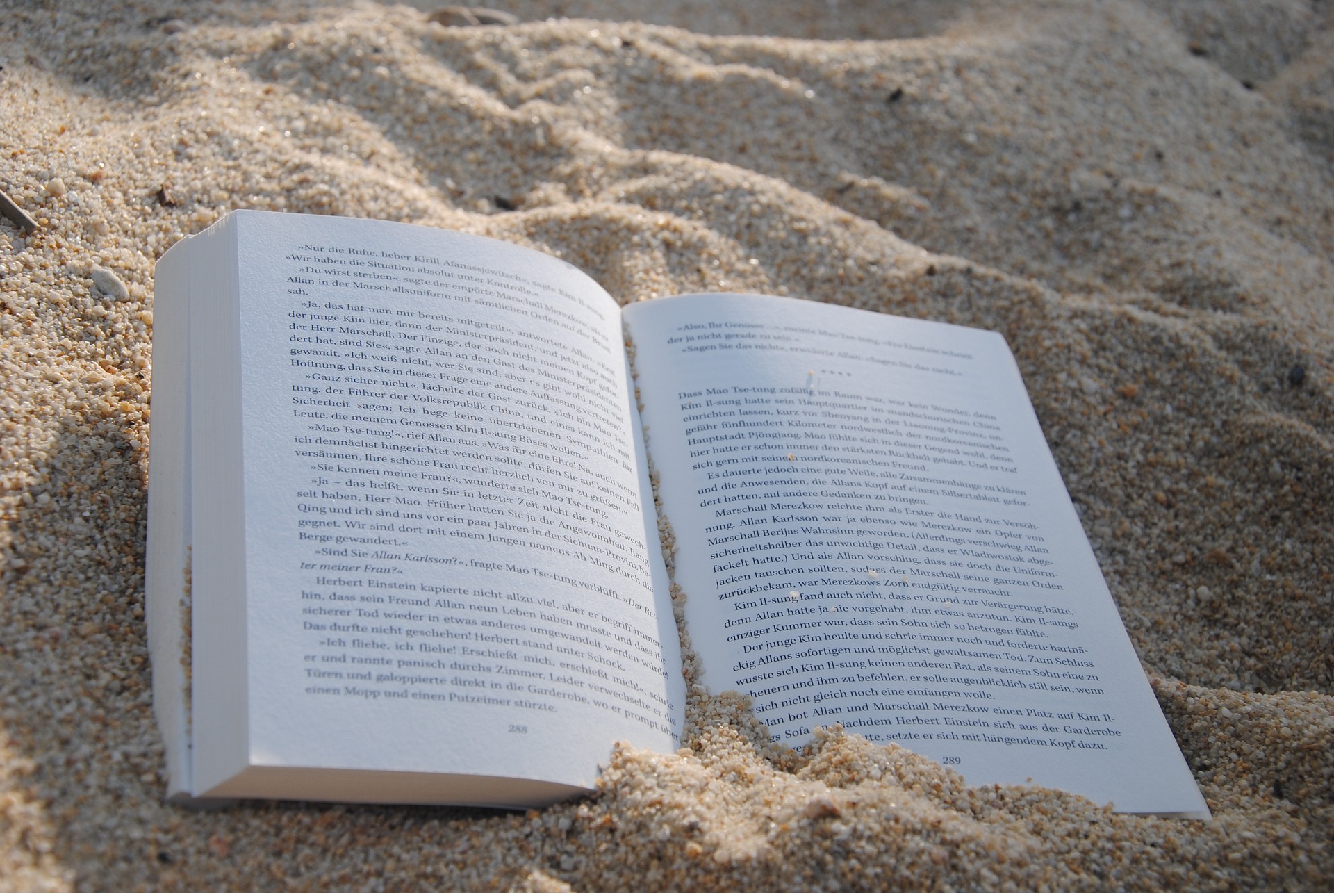 a book open in the sand on a beach