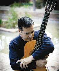 Man looking down holding guitar in his arms