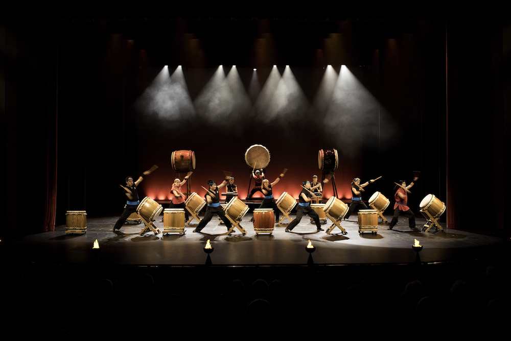 Dark stage with taiko drums and performers