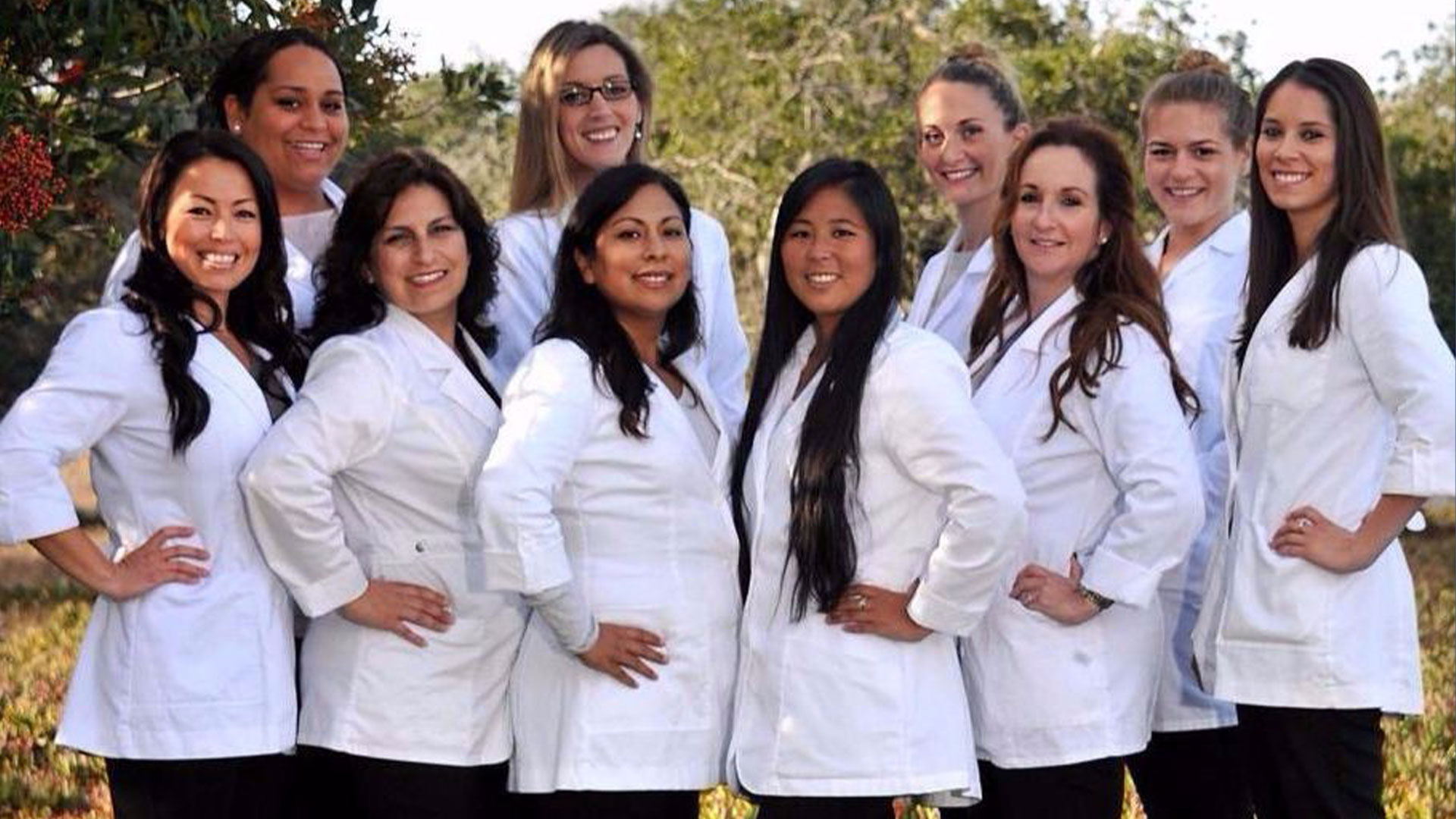 Photo: Students in the nursing program wearing white coats and posing