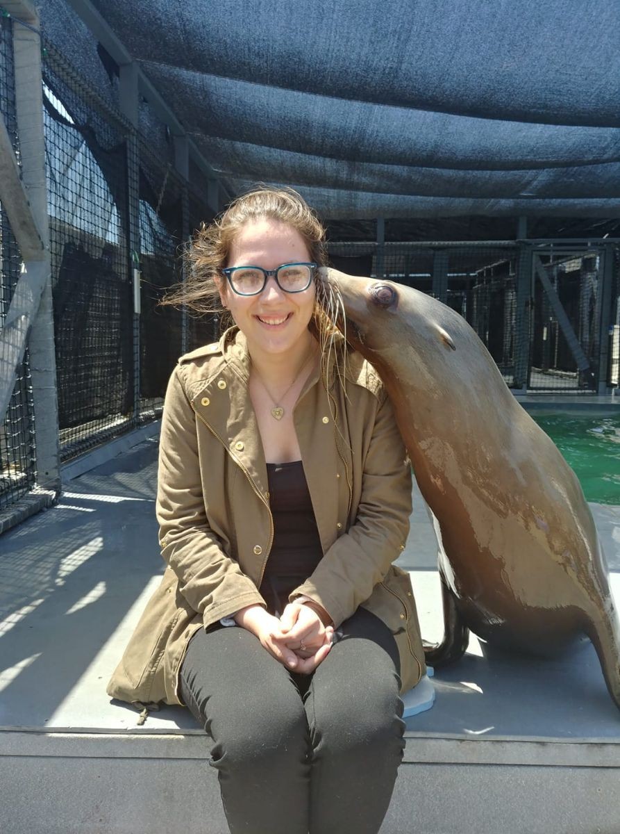 Natasha craft sitting next to a California sea lion.
