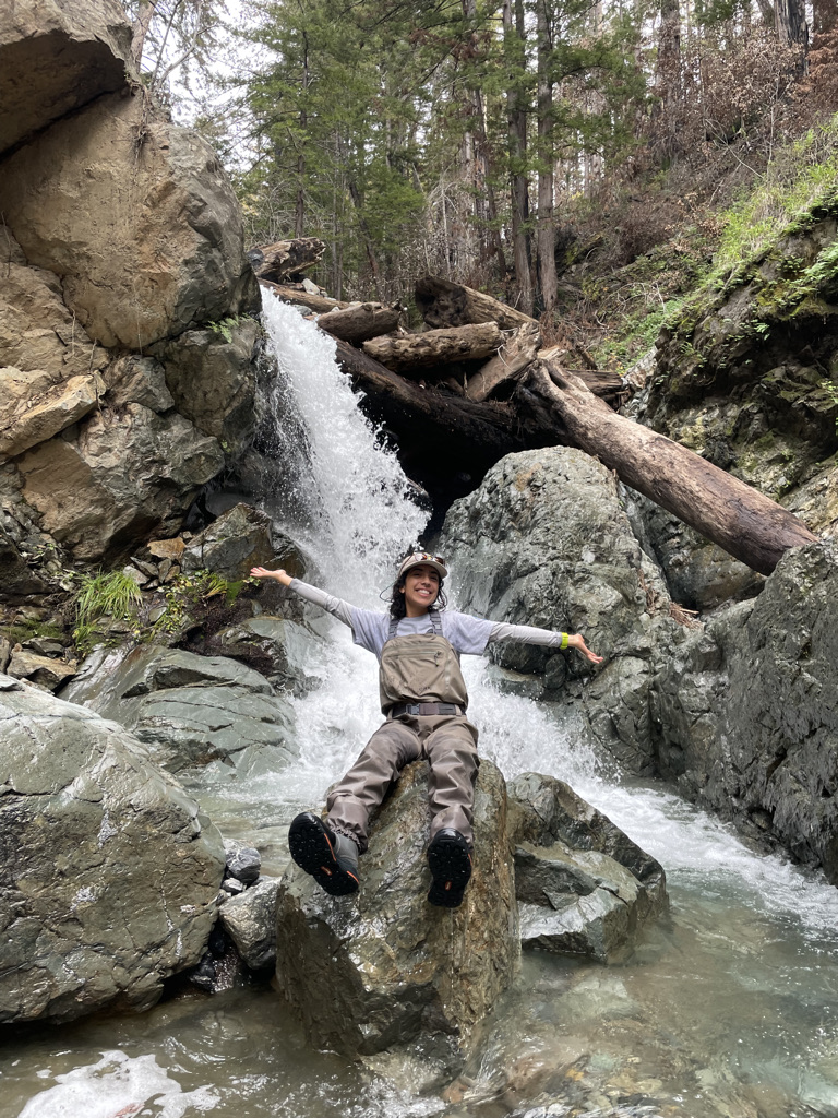 Natalie Vaughn poses in front of a waterfall