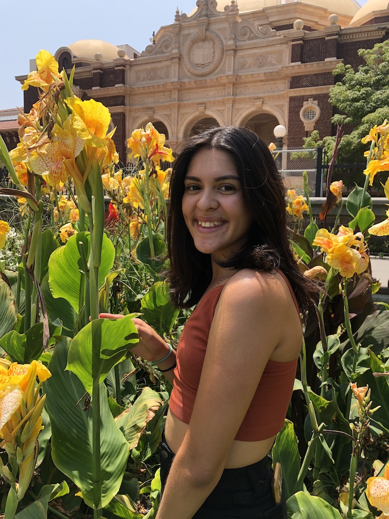 Trinity Gomez poses in a field of tall yellow flowers
