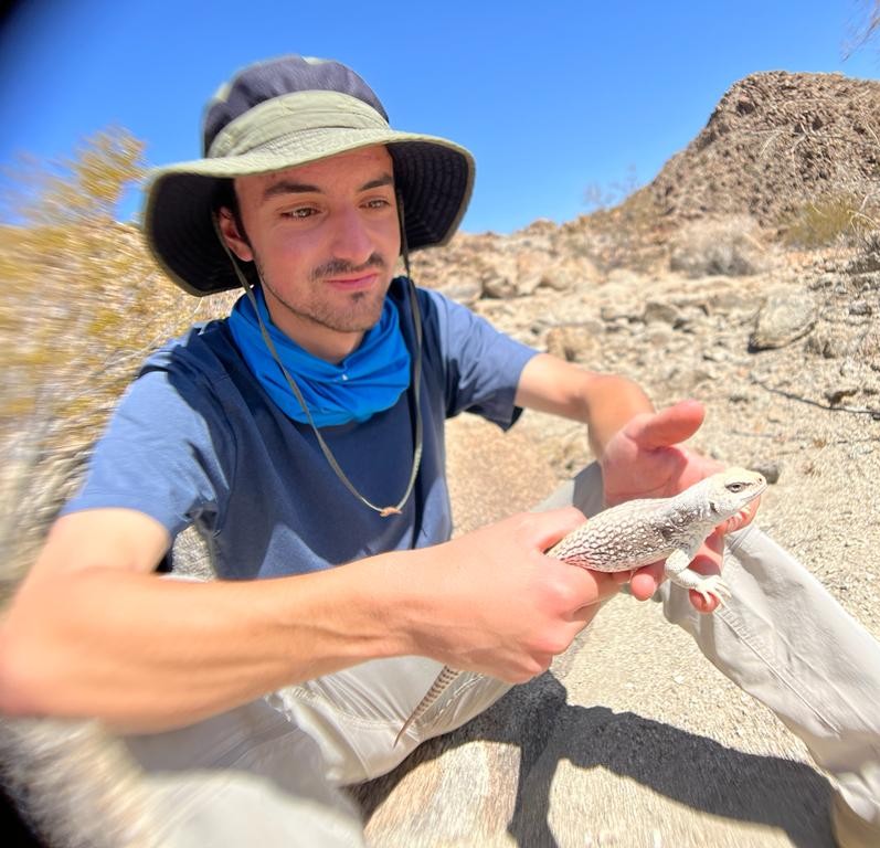 Joshua holds a lizard in the desert