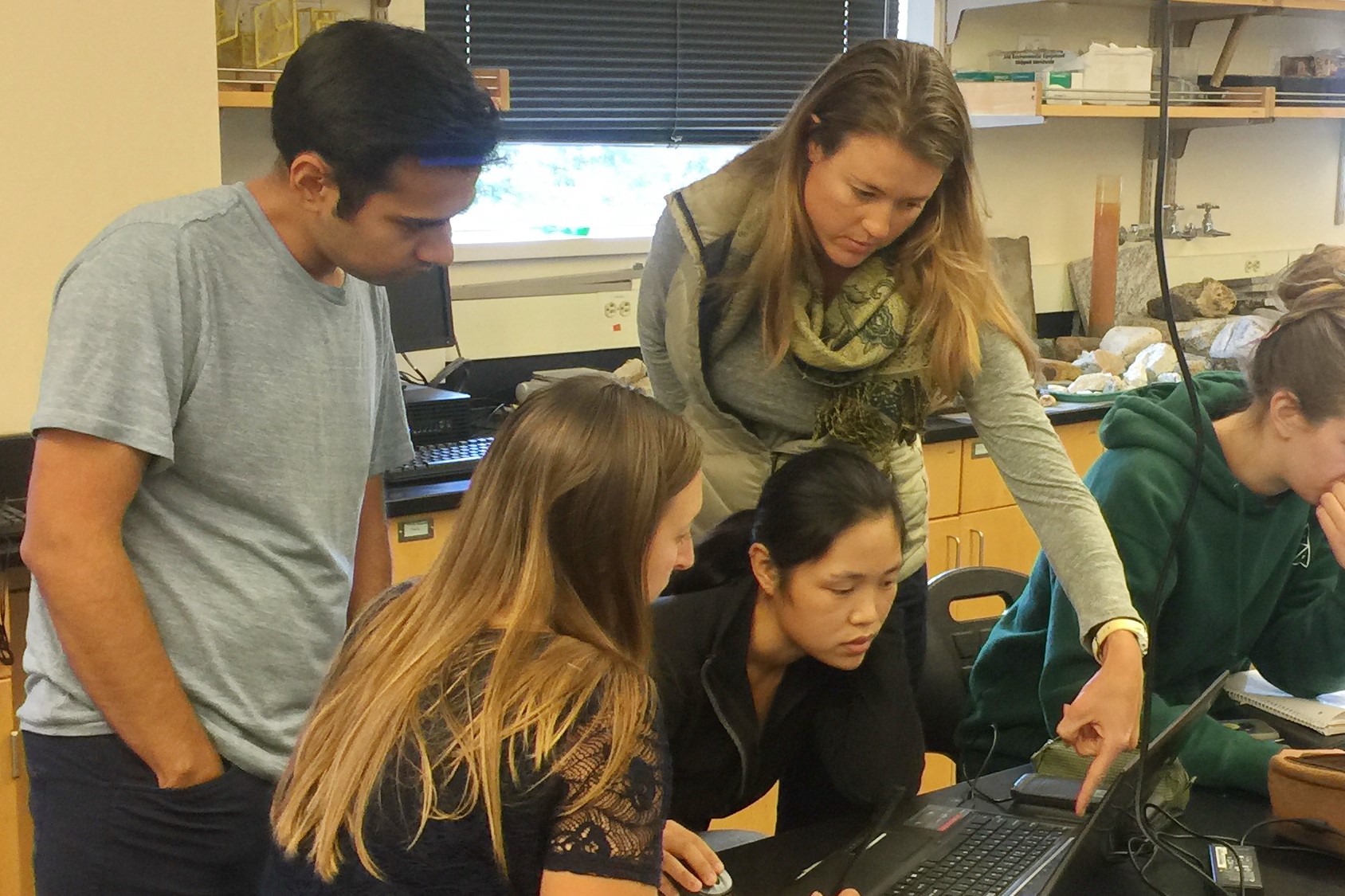 Environmental Science master's students collaborating on a computer in a science lab