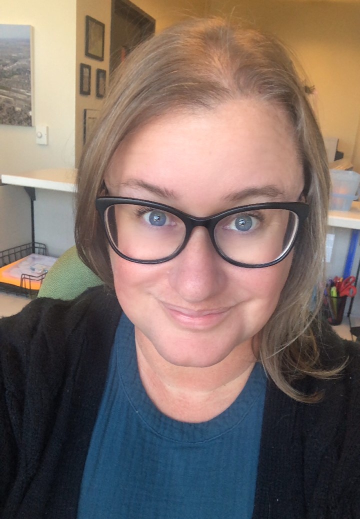 A person with glasses in an office setting.