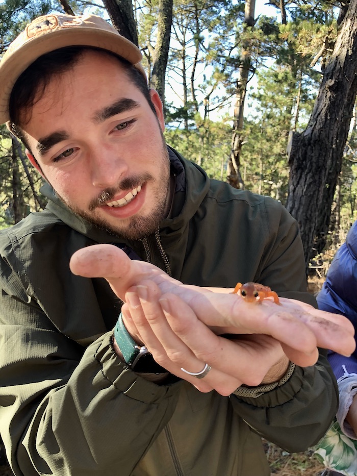 Timothy holds a salamander in his hand