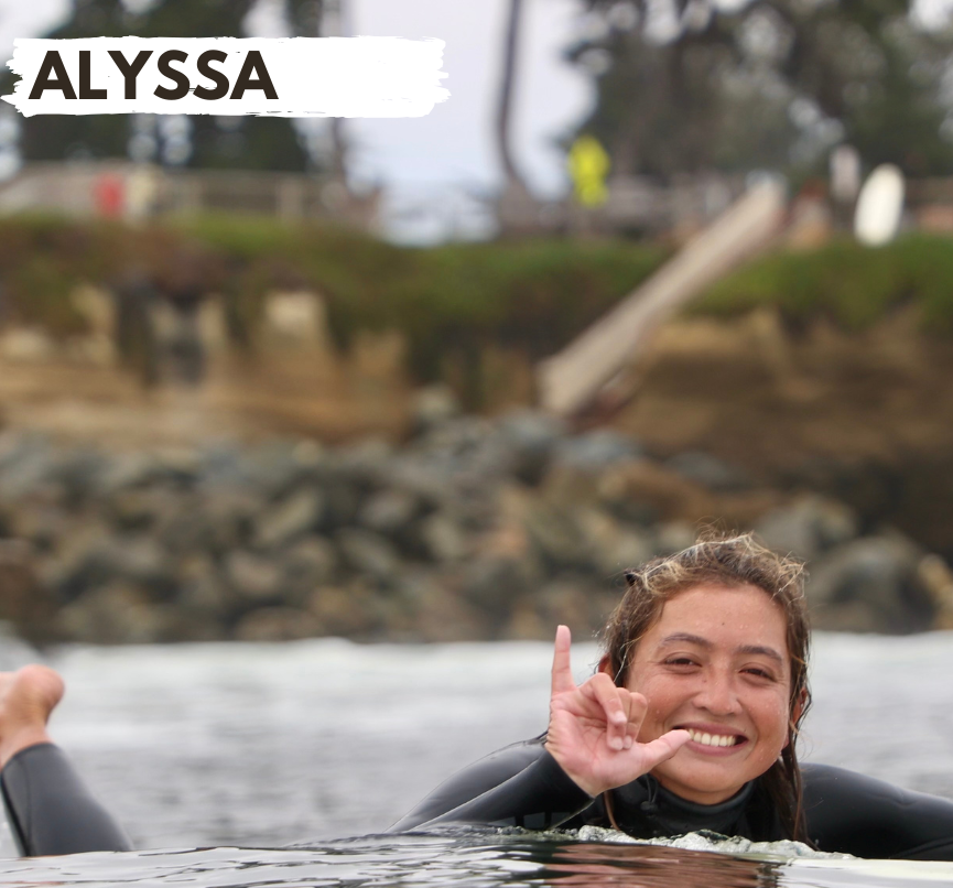 Person sitting on a surfboard submerged in water, making a