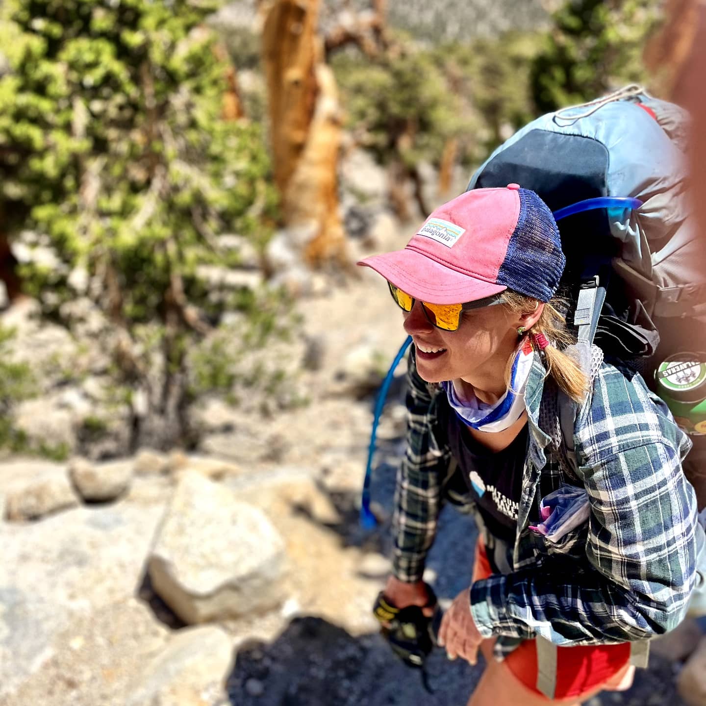 Amelia hiking with a backpack on a sunny, rocky trail.