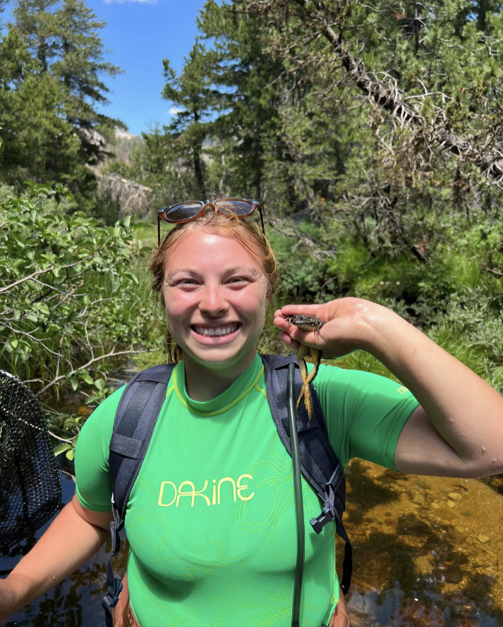 Erika is pictured holding a frog next to her face