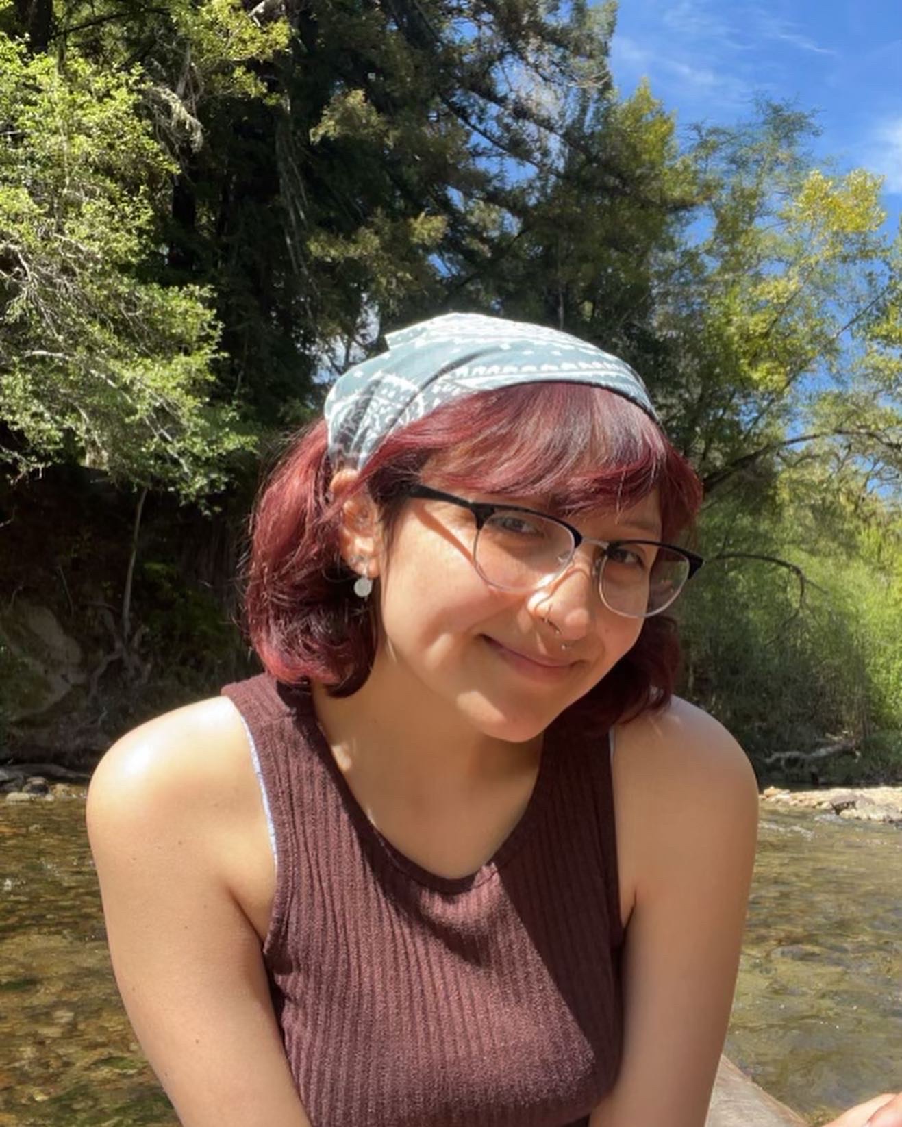 Savannah smiling for the camera while sitting in front of a creek