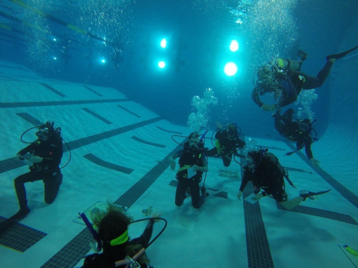 Students SCUBA diving in a deep swimming pool