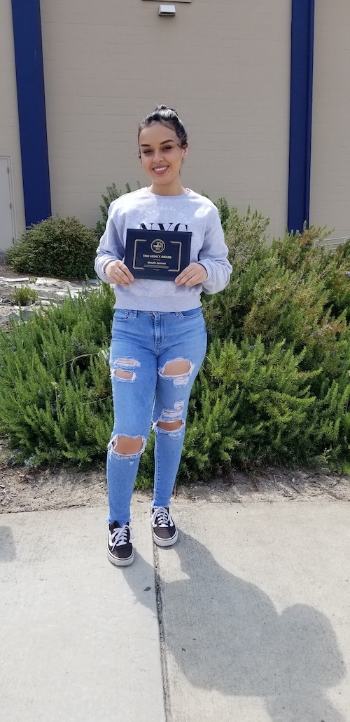 2021 TRIO Legacy Award winner Natalie Zamora holding her award plaque on campus