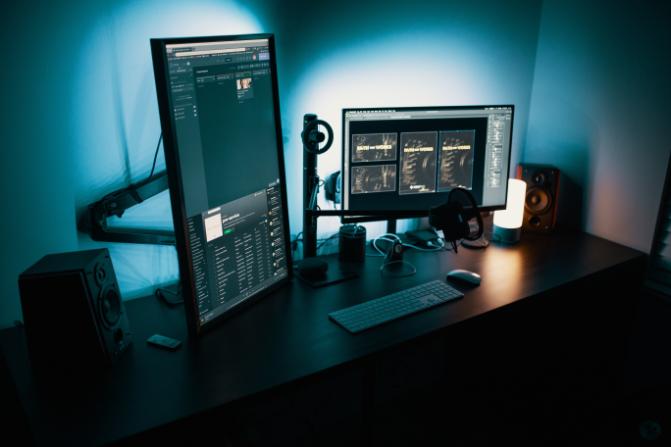 Two monitors in a dark lit room