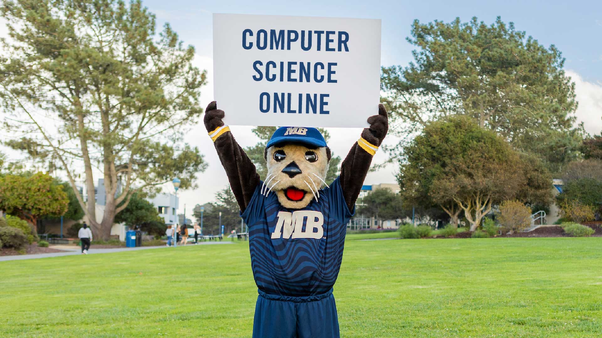 Mascot, Monte Ray holding Computer Science Online sign