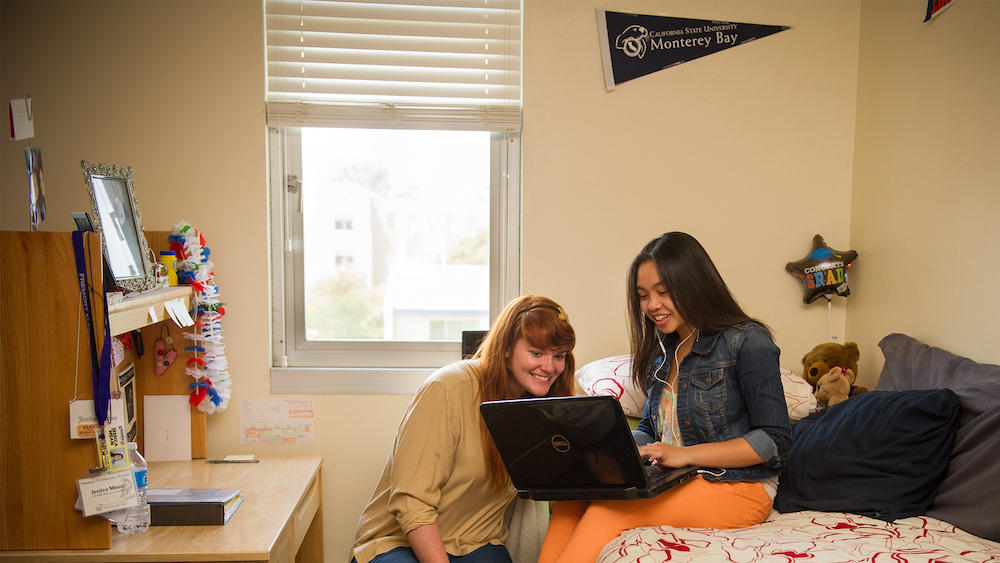 CSUMB Students in dorm room looking at laptop