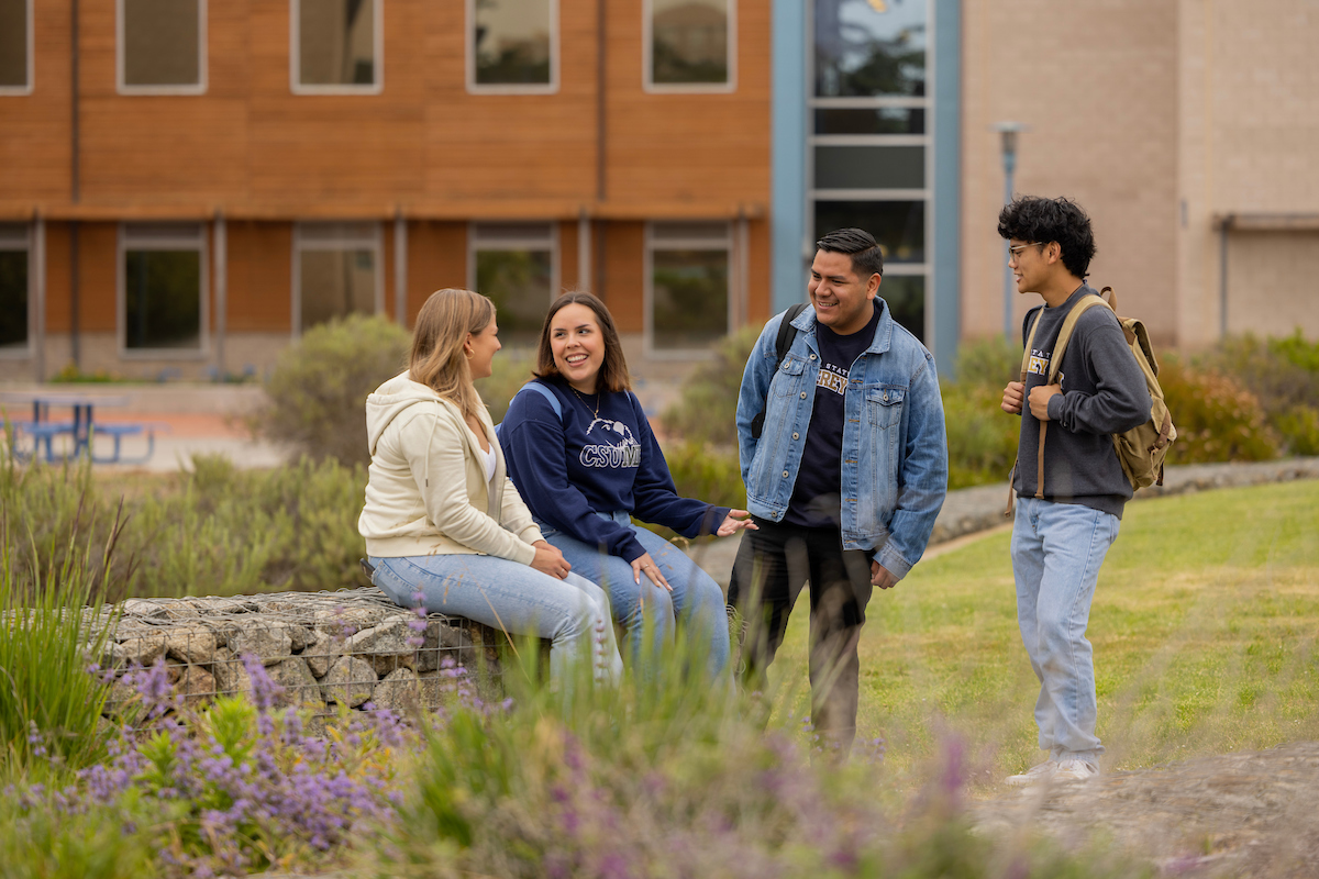 4 CSUMB students hanging out in front of the College of Science building