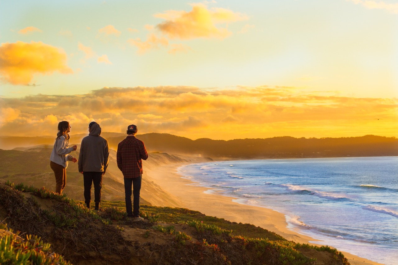 Students at a Monterey Bay beach during sunset