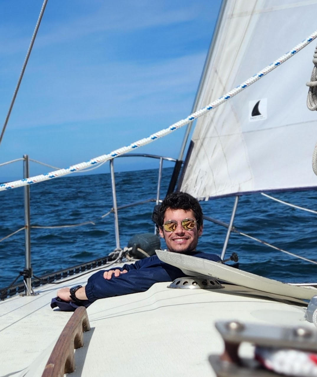 student smiling in a sailboat