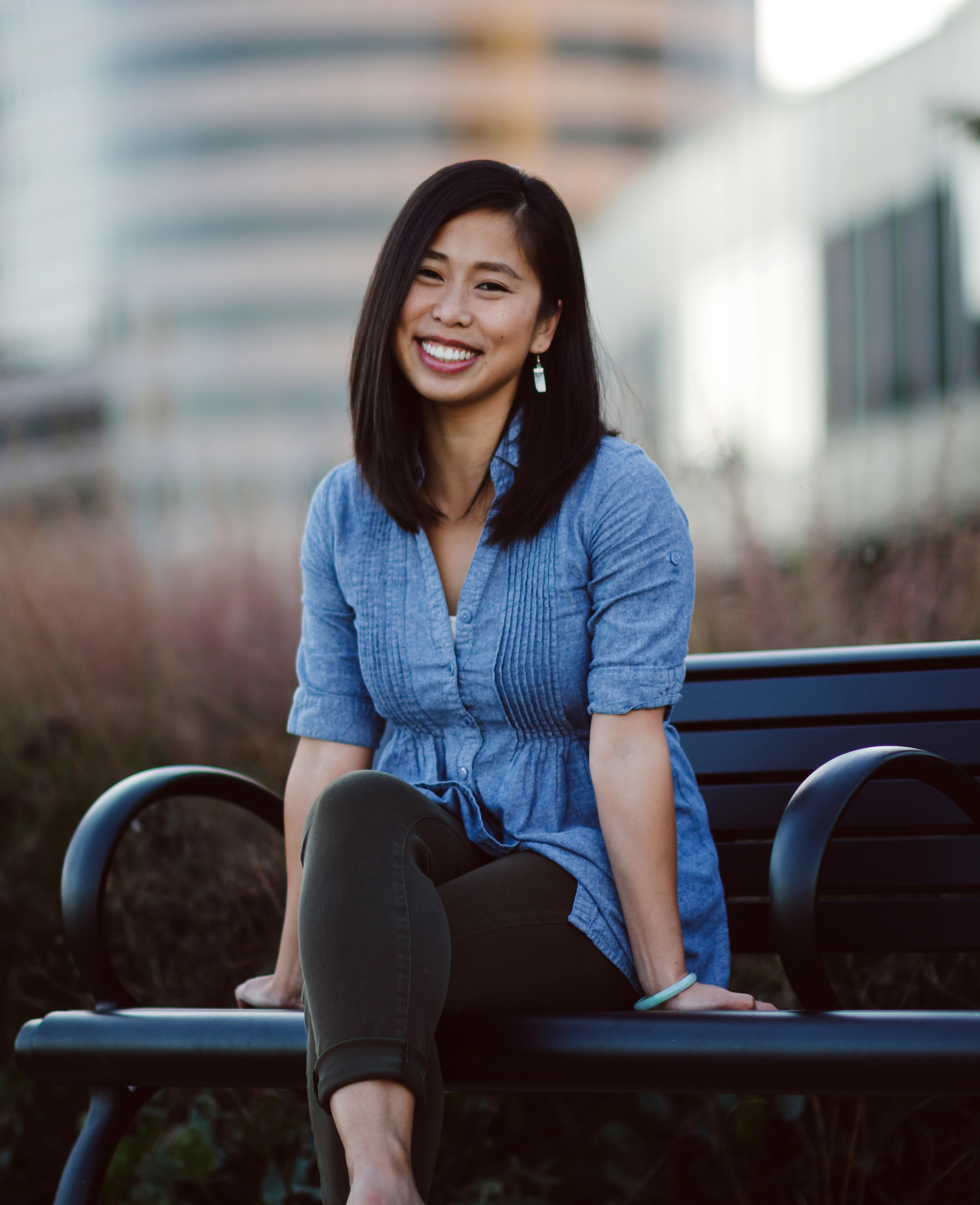 headshot of rita zhang sitting on a park bench