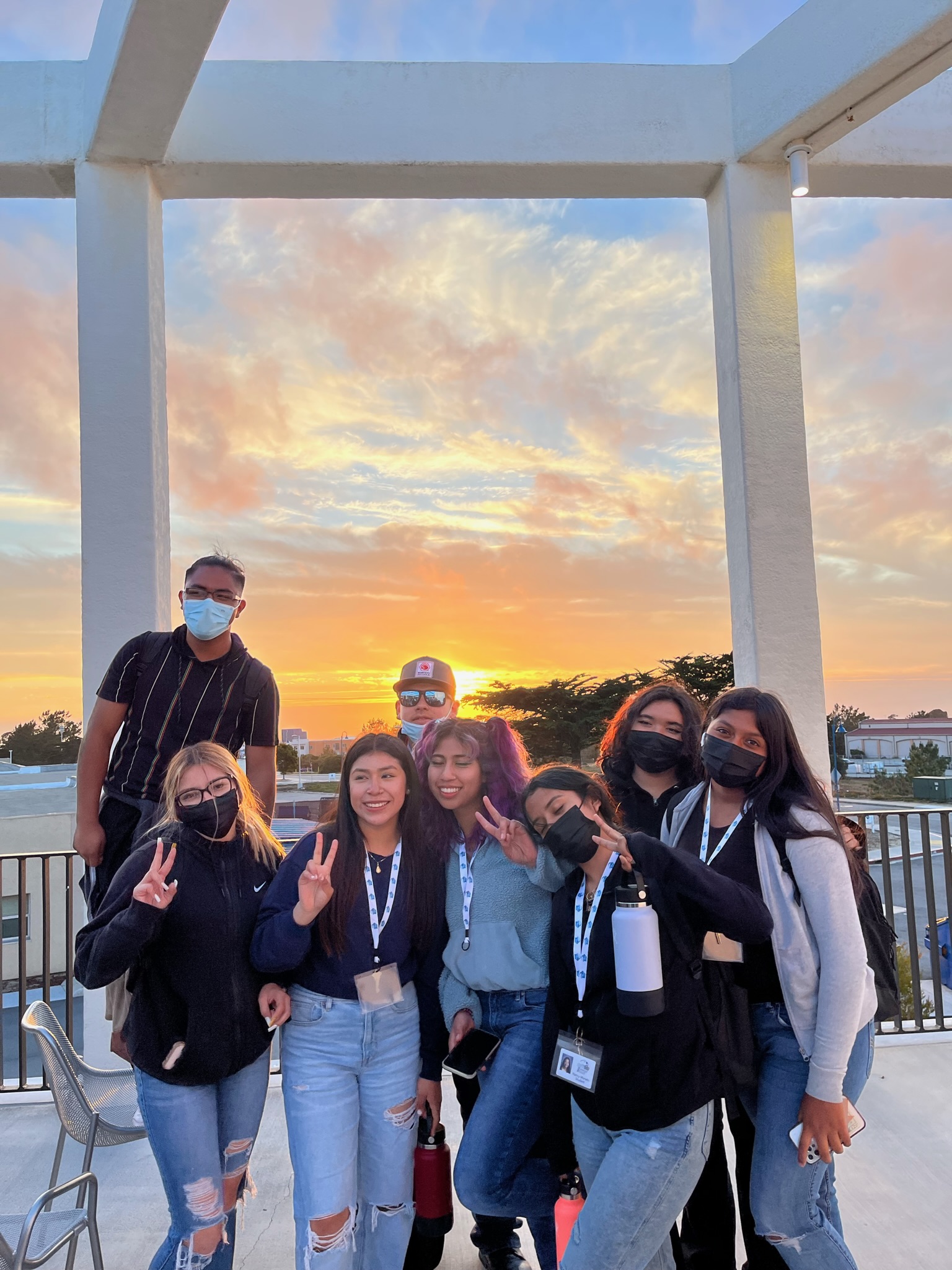 Upward Bound students posing at the Otter Student Union on a beautiful afternoon admiring the sunset.