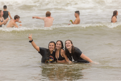 Three CSUMB students in the ocean for The Plunge