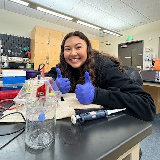 student giving thumbs up in a lab