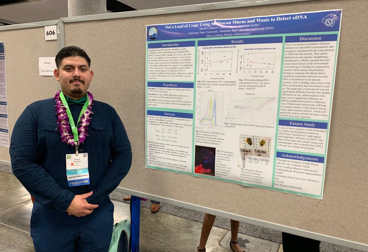 David Calderon standing in front of his research poster