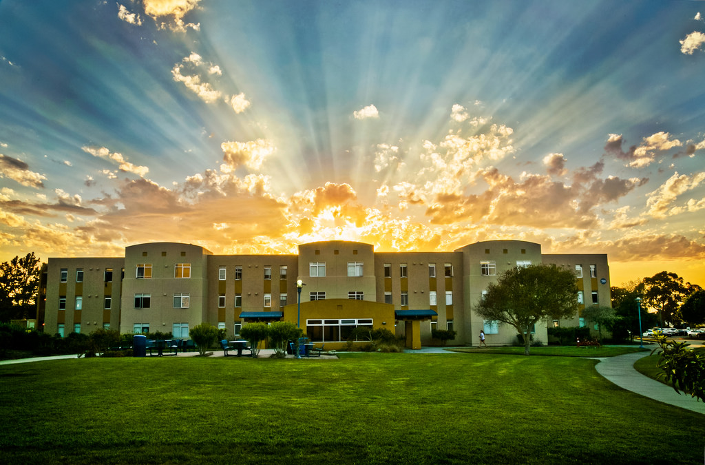 a picture of tartuga dorm hall with the sunrise behind it