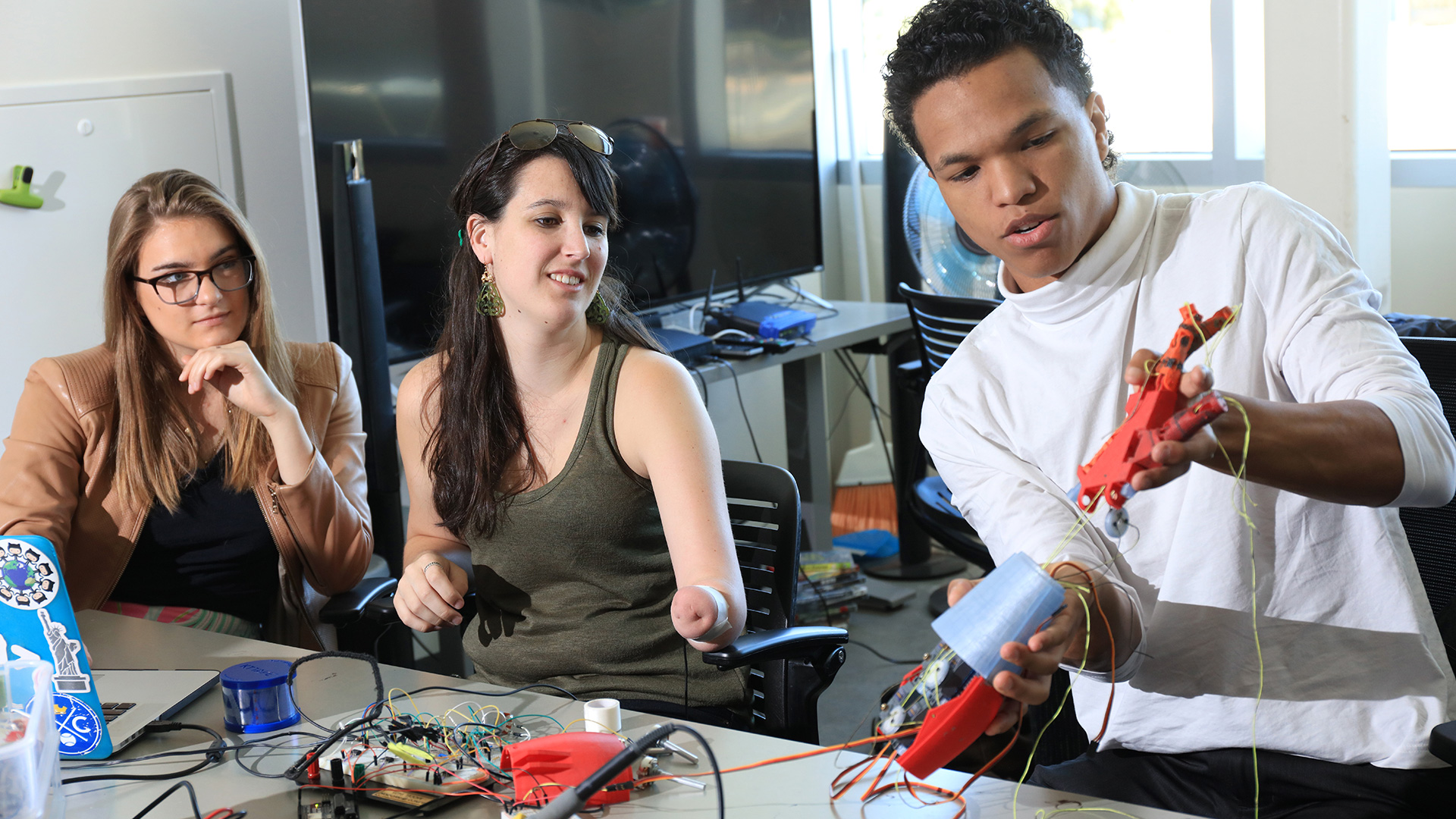 Three CSUMB Students programming prosthetic arms