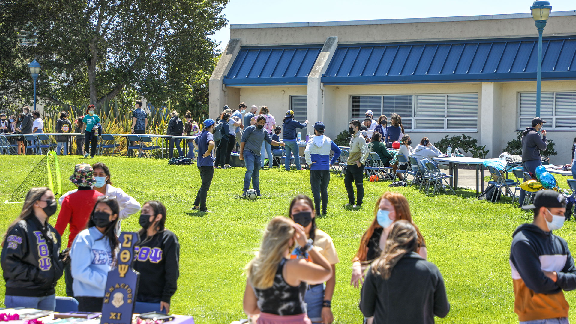 Photo: Students lining up at club and organization tables in the quad during the Otter Showcase event