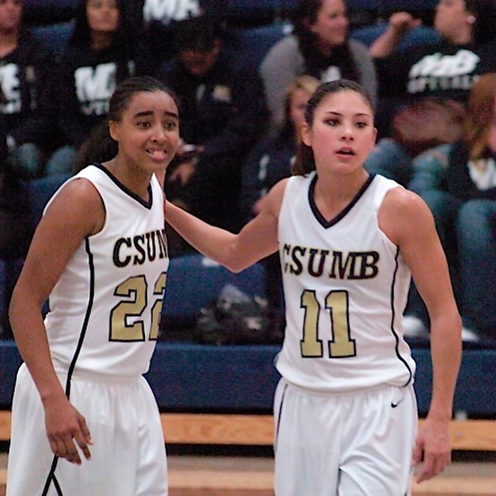 Photo: Stefanie Corgel wearing a CSUMB jersey while playing basketball, hand on teammate's shoulder