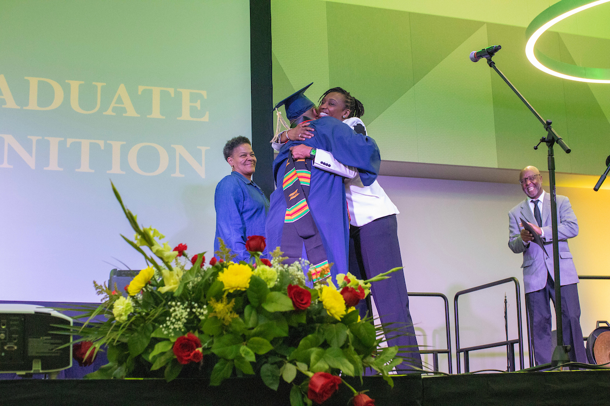 Student hugging professor at Black/African Heritage Ceremony