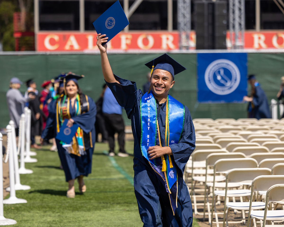 Student holding up his diploma case after the COS and COE Convocation