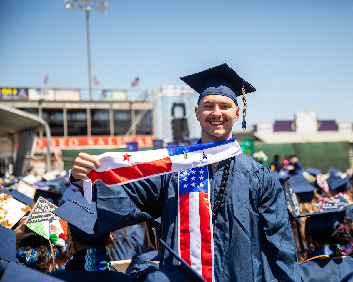 Student showing off his American Flag Stole during the COS and COE Convocation